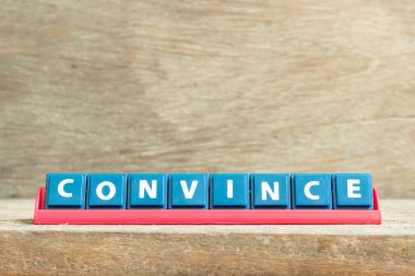 Kelime olarak kırmızı raftaki döşeme harfi ahşap arka plana ikna et