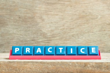 Ahşap arka planda kelime alıştırmasında kırmızı raftaki döşeme harfi