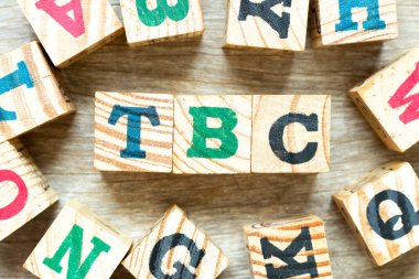 Alfabe harfi bloğu kelime TBC (doğrulanacak veya devam edecek kısaltması) ve tahta zemin üzerinde başka bir harfle