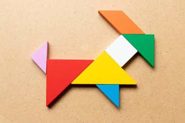 Ahşap arka planda keçi şeklinde renk tangramı yapbozu