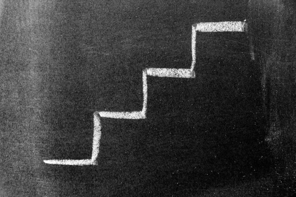 White color chalk hand drawing in staircase shape on black board background