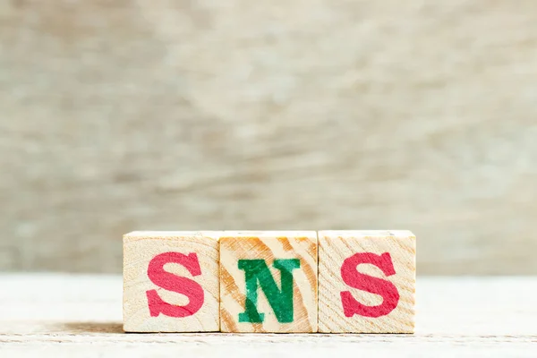 Alphabet letter in word SNS (abbreviation of Social Networking Site or sorry not sorry) on wood background