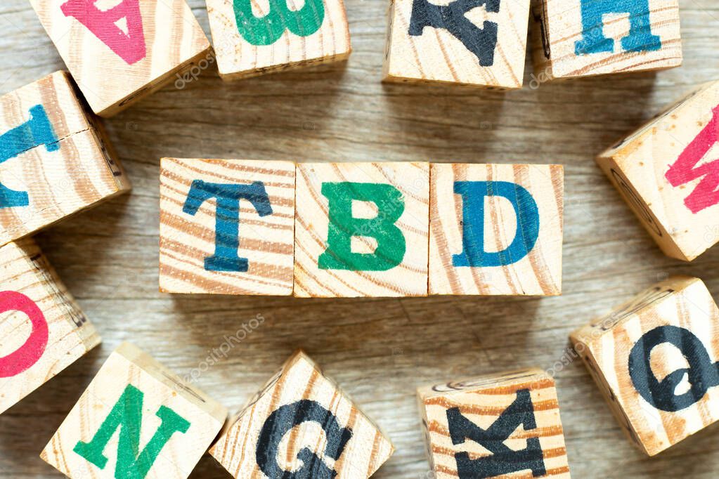Alphabet letter block in word TBD (Abbreviation of to be defined, discussed, determined, decided, deleted or declared)with another on wood background