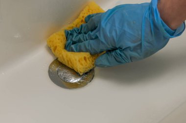 Tesisatçı ve bir musluk banyo ev kimyasal madde ile bir bez ile eldiven bir kadında yıkıyor