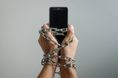 Cep telefonu bir adam, telefon bağımlılığı elleri zincirli