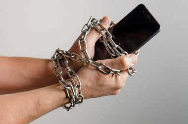 Cep telefonu bir adam, telefon bağımlılığı elleri zincirli