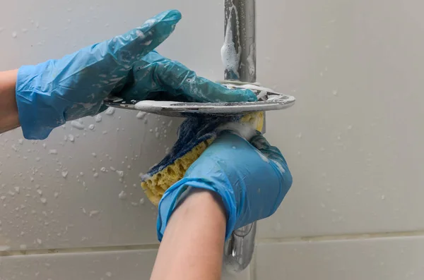 手袋の女洗浄配管 家庭用化学薬品が付いている浴室でぼろをタップ — ストック写真