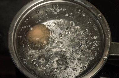 Bir tencerede kaynar suda tavuk yumurta pişirmek