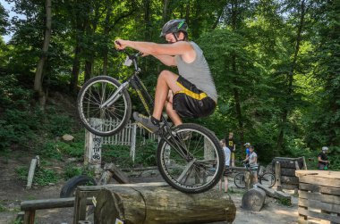 Lviv, Ukrayna - Haziran 2018: Bir bisikletçi hileci bir bisiklet üzerinde bir engel ders aşmak için deneme gerçekleştirir.