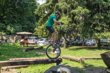 Lviv, Ukrayna - Haziran 2018: Bir bisikletçi hileci bir bisiklet üzerinde bir engel ders aşmak için deneme gerçekleştirir.