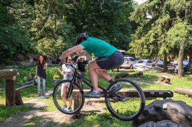 Lviv, Ukrayna - Haziran 2018: Bir bisikletçi hileci bir bisiklet üzerinde bir engel ders aşmak için deneme gerçekleştirir.