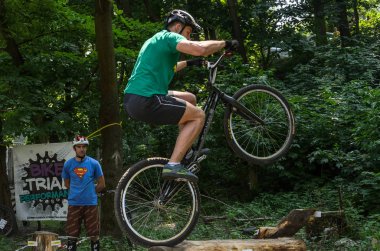 Lviv, Ukrayna - Haziran 2018: Bir bisikletçi hileci bir bisiklet üzerinde bir engel ders aşmak için deneme gerçekleştirir.