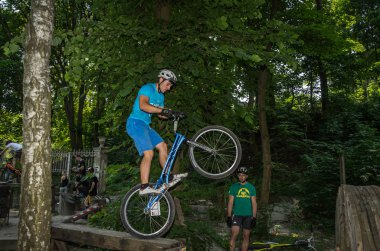 Lviv, Ukrayna - Haziran 2018: Bir bisikletçi hileci bir bisiklet üzerinde bir engel ders aşmak için deneme gerçekleştirir.