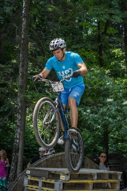 Lviv, Ukrayna - Haziran 2018: Bir bisikletçi hileci bir bisiklet üzerinde bir engel ders aşmak için deneme gerçekleştirir.