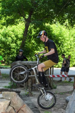 Lviv, Ukrayna - Haziran 2018: Bir bisikletçi hileci bir bisiklet üzerinde bir engel ders aşmak için deneme gerçekleştirir.