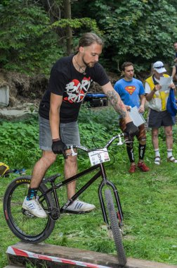 Lviv, Ukrayna - Haziran 2018: Bir bisikletçi hileci bir bisiklet üzerinde bir engel ders aşmak için deneme gerçekleştirir.