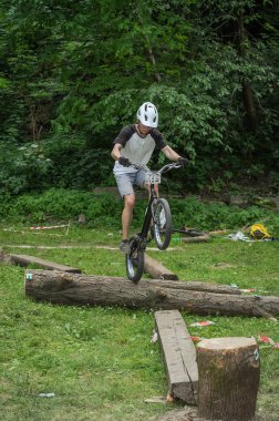 Lviv, Ukrayna - Haziran 2018: Bir bisikletçi hileci bir bisiklet üzerinde bir engel ders aşmak için deneme gerçekleştirir.