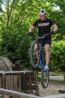 Lviv, Ukrayna - Haziran 2018: Bir bisikletçi hileci bir bisiklet üzerinde bir engel ders aşmak için deneme gerçekleştirir.