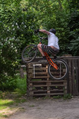 Lviv, Ukrayna - Haziran 2018: Bir bisikletçi hileci bir bisiklet üzerinde bir engel ders aşmak için deneme gerçekleştirir.