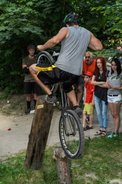 Lviv, Ukrayna - Haziran 2018: Bir bisikletçi hileci bir bisiklet üzerinde bir engel ders aşmak için deneme gerçekleştirir.