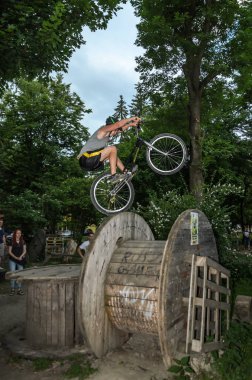 Lviv, Ukrayna - Haziran 2018: Bir bisikletçi hileci bir bisiklet üzerinde bir engel ders aşmak için deneme gerçekleştirir.