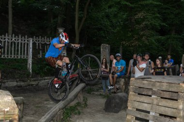 Lviv, Ukrayna - Haziran 2018: Bir bisikletçi hileci bir bisiklet üzerinde bir engel ders aşmak için deneme gerçekleştirir.
