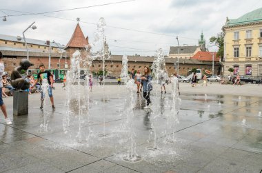 Lviv, Ukrayna - Haziran 2018: Gençler ve çocuklar kentin fıskiyede oynamak