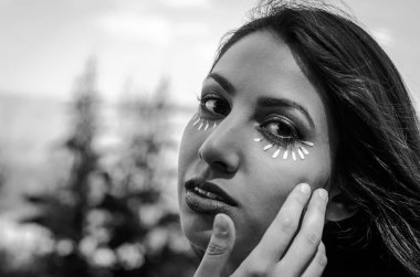 Göz makyaj yaparken genç çekici kız papatya çiçek yaprakları kullanarak