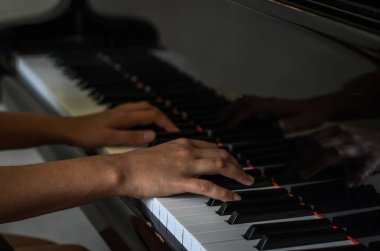 Ellerinde siyah beyaz piyano tuşları