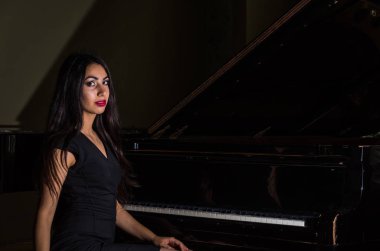 Genç çekici esmer kız piyano