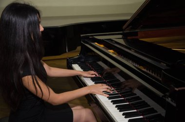 Genç çekici esmer kız piyano