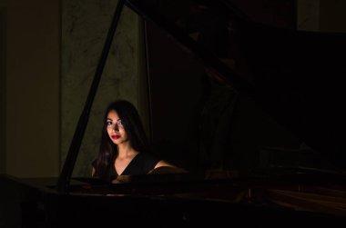 Genç çekici esmer kız piyano