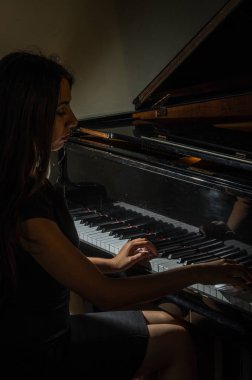 Genç çekici esmer kız piyano