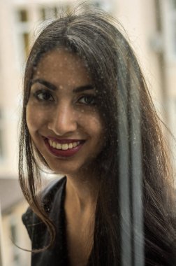 Bir cam pencere arkasında genç çekici esmer kız