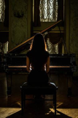 Genç çekici esmer kız piyano