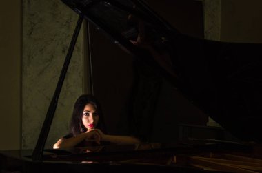 Genç çekici esmer kız piyano