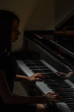 Genç çekici esmer kız piyano