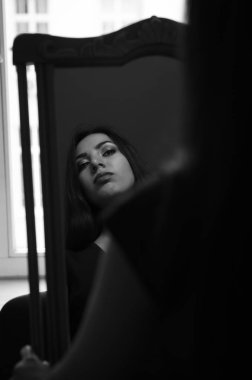 Genç çekici esmer kız yansıması aynaya bakar