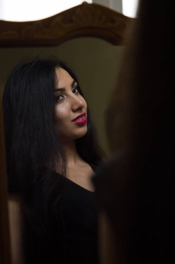 Genç çekici esmer kız yansıması aynaya bakar