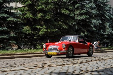 Lviv, Ukrayna - Haziran 2018: Şehrin sokaklarında eski vintage kırmızı retro cabriolet Mg araba sürmek