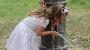 Küçük sevimli bebek kız elbise içme suyu sıcak yaz gününde bir Roma Çeşmesi '