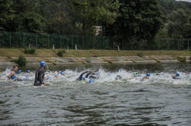 Ukrayna, Lviv - Eylül 2018: Sporcular yüzücüler wetsuits gölde boyunca triatlon yarışma sırasında yüzmek
