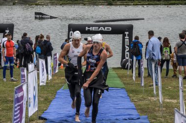 Ukrayna, Lviv - Eylül 2018: Bir atlet takım elbiseli hidro-sudan yüzdükten sonra bir triatlon yarışma sırasında çalışır