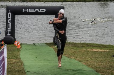 Ukrayna, Lviv - Eylül 2018: Bir atlet takım elbiseli hidro-sudan yüzdükten sonra bir triatlon yarışma sırasında çalışır