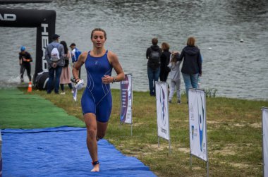 Ukrayna, Lviv - Eylül 2018: Bir atlet takım elbiseli hidro-sudan yüzdükten sonra bir triatlon yarışma sırasında çalışır