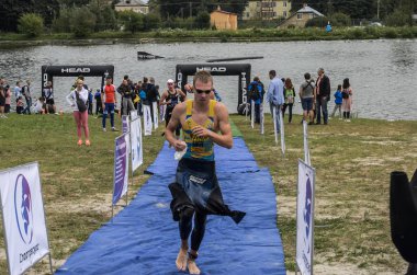 Ukrayna, Lviv - Eylül 2018: Bir atlet takım elbiseli hidro-sudan yüzdükten sonra bir triatlon yarışma sırasında çalışır