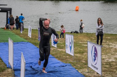 Ukrayna, Lviv - Eylül 2018: Bir atlet takım elbiseli hidro-sudan yüzdükten sonra bir triatlon yarışma sırasında çalışır