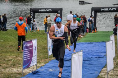 Ukrayna, Lviv - Eylül 2018: Bir atlet takım elbiseli hidro-sudan yüzdükten sonra bir triatlon yarışma sırasında çalışır