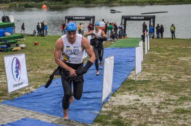 Ukrayna, Lviv - Eylül 2018: Bir atlet takım elbiseli hidro-sudan yüzdükten sonra bir triatlon yarışma sırasında çalışır