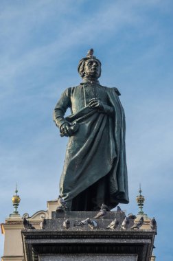 Polonya, Krakow - Kasım 2018: Adam Mickiewicz, Krakow, Polonya pazarının merkezi kare üzerinde oturan güvercin anıt
